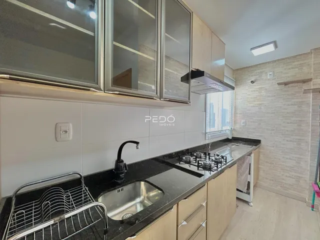 Uma cozinha moderna com armários e bancada escura.