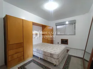 Quarto com armários de madeira e cama.