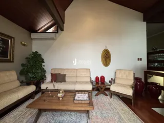 Sala de estar com sofá e poltronas em ambiente bem iluminado.