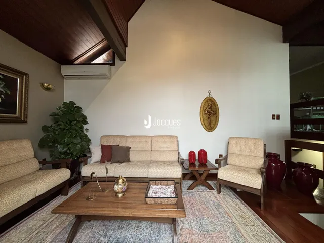 Sala de estar com sofá e poltronas em ambiente bem iluminado.