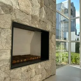 Nicho decorativo em parede de pedra com moldura escura.