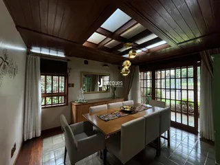 Vista interna de uma sala de jantar com teto abobadado e piso de madeira.