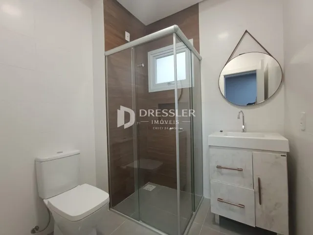 Banheiro com box de vidro e bancada de mármore.