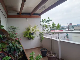 Vista de uma varanda com plantas e grade de segurança.