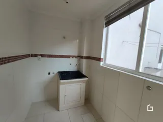 Interior de um cômodo com paredes brancas e piso de cerâmica.