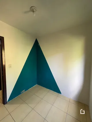 Foto do interior de uma sala com paredes anguladas e piso de cerâmica.