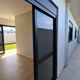 Ambiente interno com piso de madeira e porta de vidro.
