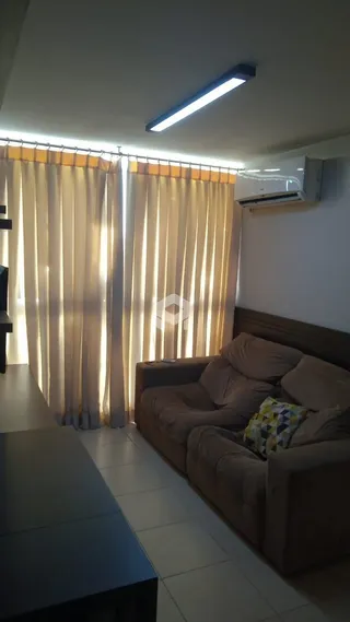 Quarto com cortinas claras e móveis de madeira.