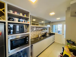 Cozinha moderna com armários brancos e bancadas escuras.