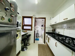 Foto de uma cozinha com armários brancos e piso de cerâmica.