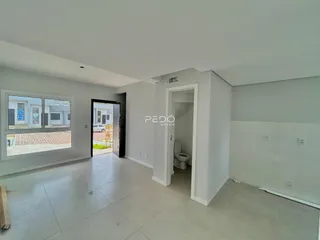 Sala de estar com piso de cerâmica e porta de entrada para o banheiro.