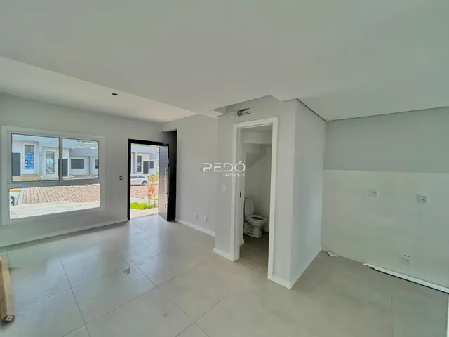 Sala de estar com piso de cerâmica e porta de entrada para o banheiro.