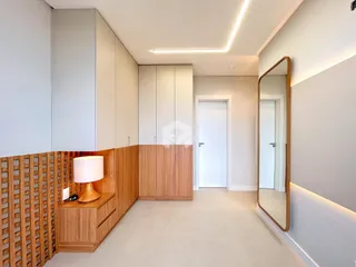 Interior de um corredor com painéis de madeira e paredes brancas.