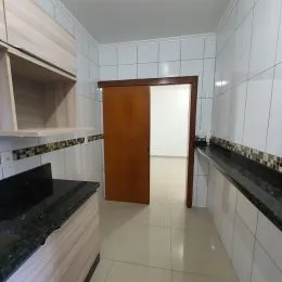 Hall de passagem com paredes brancas e piso claro em um imóvel.