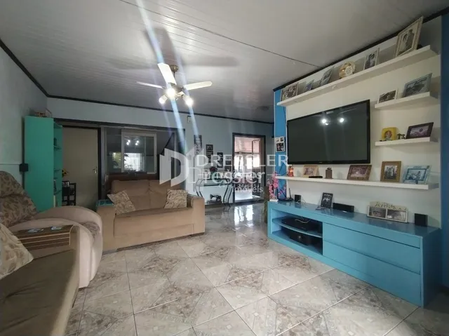 Sala de estar com sofá e televisão em um imóvel no Brasil.