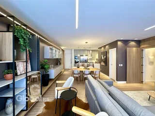 Sala de estar e cozinha de um apartamento moderno com piso de madeira.