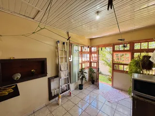 Interior de uma sala com piso de cerâmica e janelas que dão para o exterior.