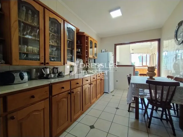 Armários de madeira com bancada e piso cerâmico de uma cozinha.