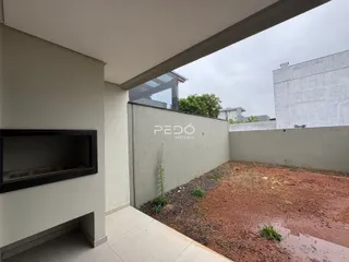 Vista da fachada de uma propriedade com um pátio de terra no fundo.