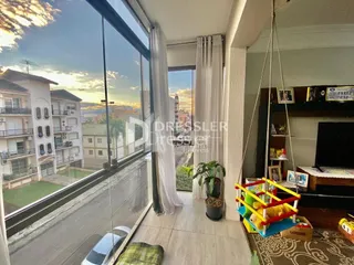 Vista da sala de estar com porta de vidro abrindo para o exterior.
