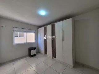 Quarto com armários embutidos e piso de cerâmica em um imóvel no Brasil.