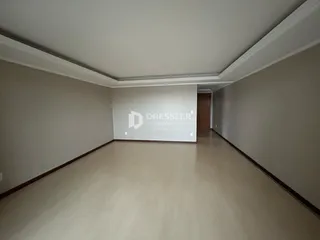 Corredor interno de um imóvel com piso claro e molduras brancas.