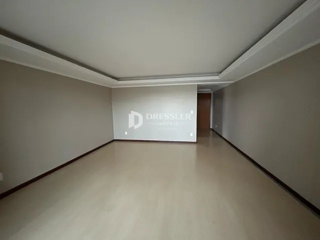 Corredor interno de um imóvel com piso claro e molduras brancas.