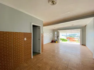 Hall de entrada com piso de cerâmica e parede de tijolos aparentes.