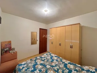 Quarto com armário de madeira e cama decorada.