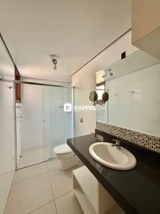 Foto de um banheiro moderno com revestimento de azulejos e bancada escura.