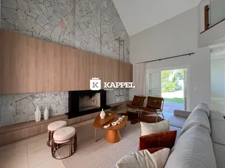 Sala de estar com lareira e área externa visível.