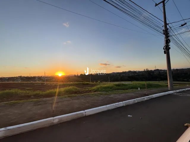 Paisagem de campo ao pôr do sol com uma estrada no primeiro plano.