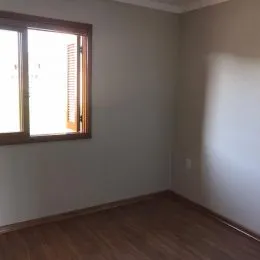 Ambiente interno com piso de madeira e janela grande.
