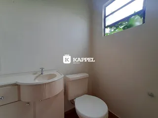 Banheiro com pia e vaso sanitário branco.