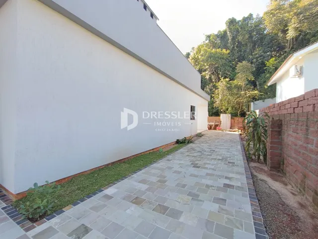 Fachada de uma residência com calçada de pedras e jardim.