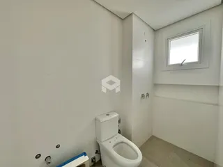 Foto de um banheiro interno com vaso sanitário branco e paredes brancas.