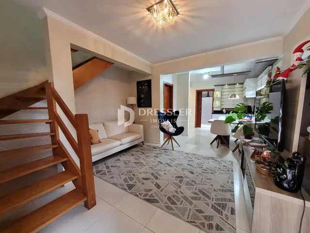 Sala de estar com piso de cerâmica e escadaria de madeira.