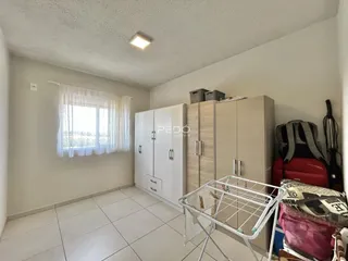 Quarto com armários embutidos e piso de cerâmica claro.