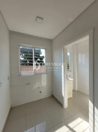 Hall de entrada com piso de cerâmica e parede branca em uma residência.