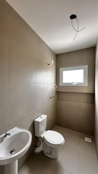 A foto mostra um banheiro interno com pia e vaso sanitário.