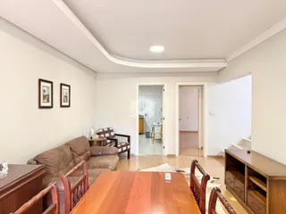 Sala de estar com sofá e móveis de madeira em um imóvel no Brasil.