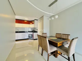 Ambiente de sala de estar e jantar com cozinha aberta em um imóvel no Brasil.