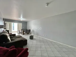 Sala de estar e jantar com piso de cerâmica clara.
