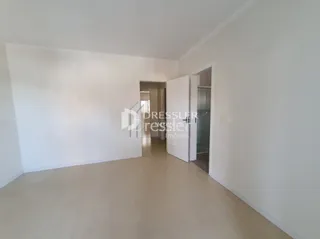 Interior de um cômodo com paredes brancas e piso claro.