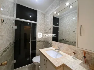 Banheiro com revestimento de azulejos e bancada de granito.