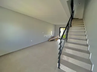 Interior de um espaço amplo com paredes cinzas e escadaria.