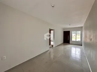 Vista interna de um ambiente com piso de cerâmica e paredes brancas.
