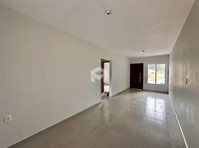Vista interna de um ambiente com piso de cerâmica e paredes brancas.