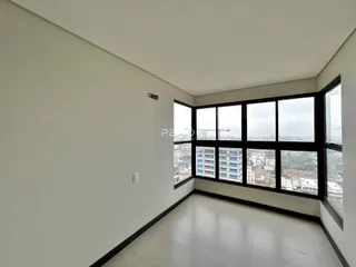 Vista de uma sala com grandes janelas que oferecem uma vista da paisagem urbana.