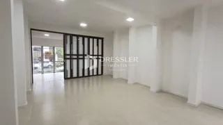 Corredor interno com portas de vidro e piso claro.